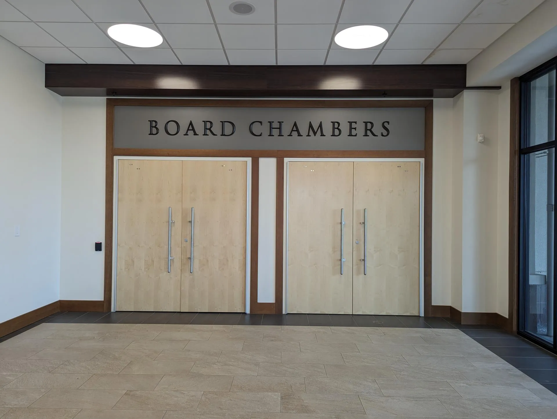 Double wooden doors beneath a sign reading Board Chambers